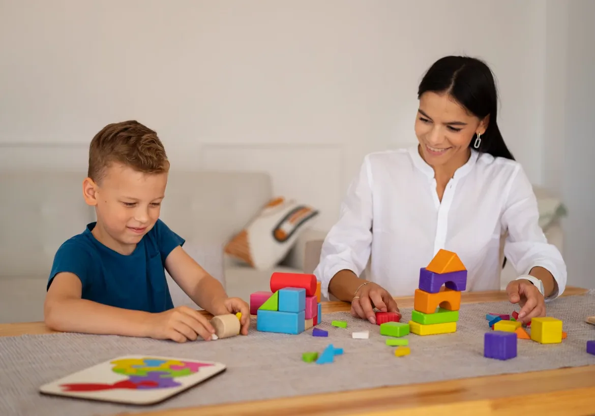 Young child playing with building blocks alongside an adult