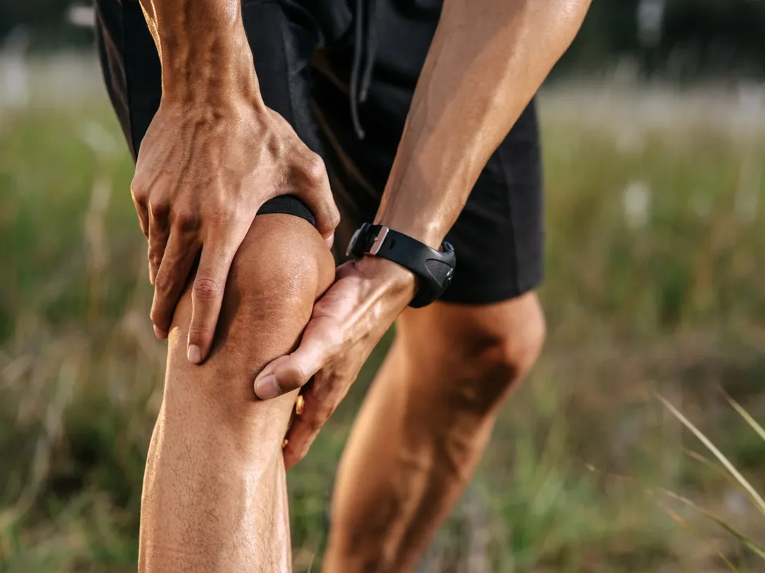 Runner holding his knee outdoors