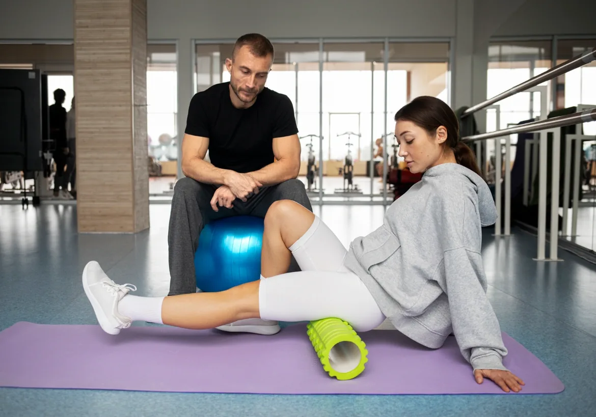 Clinician working with a patient on a mat with an exercise ball