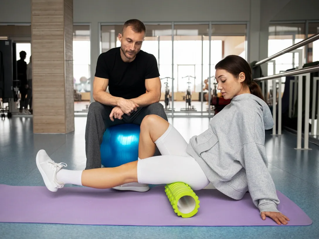 Clinician working with a patient on a mat with an exercise ball
