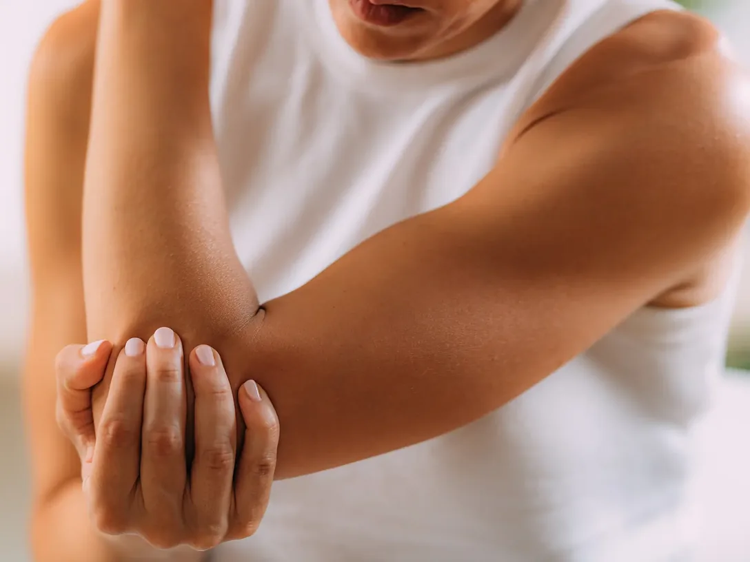 Person holding a sore elbow