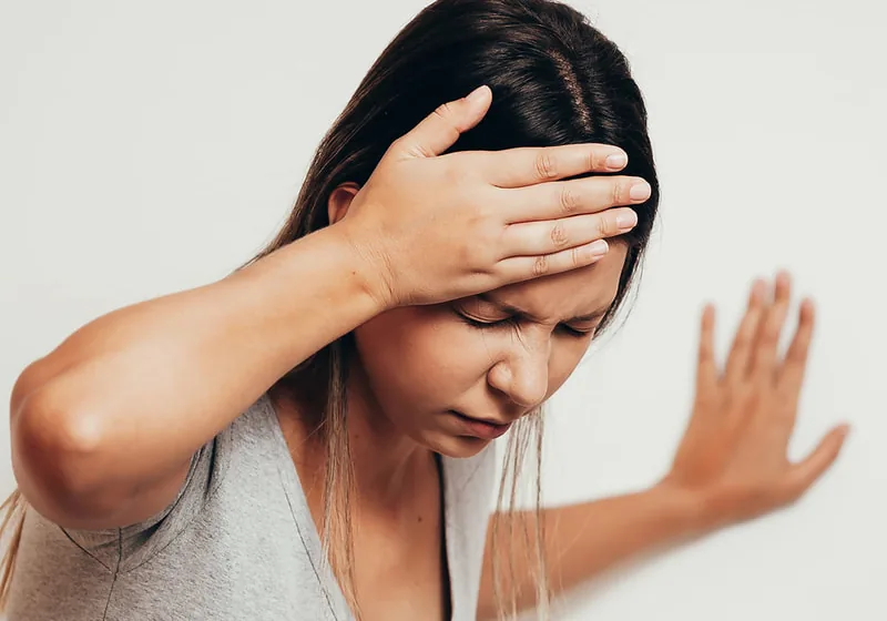Woman holding her neck and head in discomfort