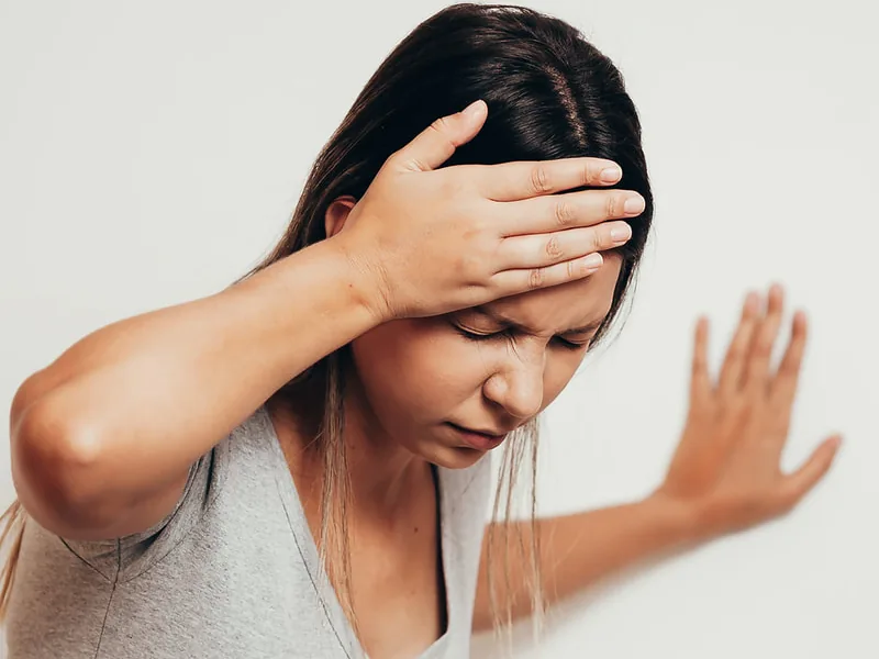 Woman holding her neck and head in discomfort