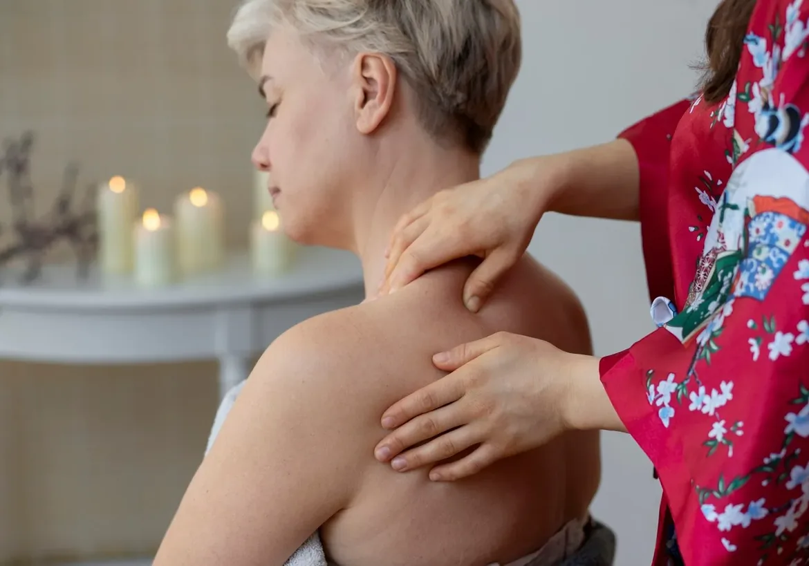Therapist working on a woman's upper back and shoulder