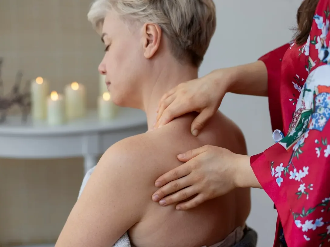 Therapist working on a woman's upper back and shoulder