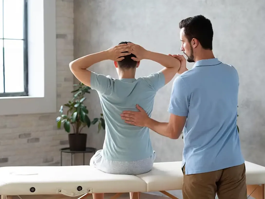 Clinician assessing a seated patient's upper back