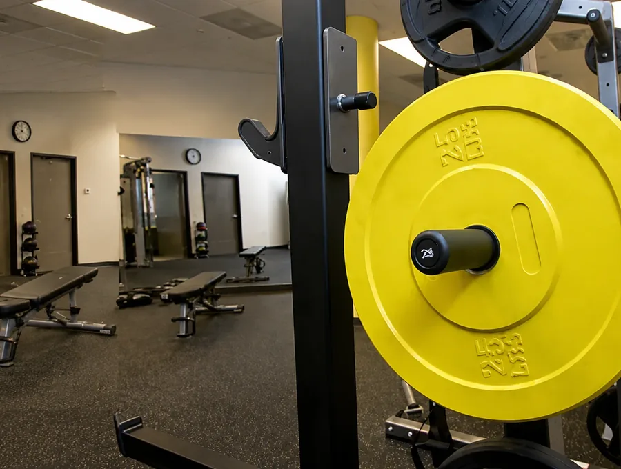 Weight rack and benches in the clinic's strength training area